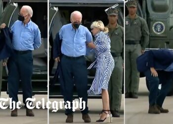 Joe Biden struggles to get his jacket on before dropping his sunglasses