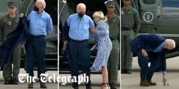 Joe Biden struggles to get his jacket on before dropping his sunglasses
